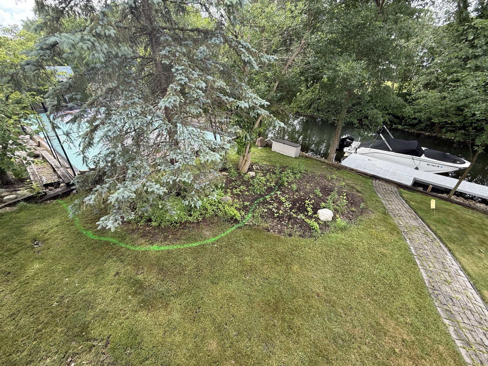 Lakefront yard with beds only marked out in paint before landscaping